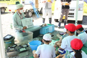 「ナマズのがっこう」の三塚牧夫事務局長からカエルの種類の見分け方について学ぶ児童