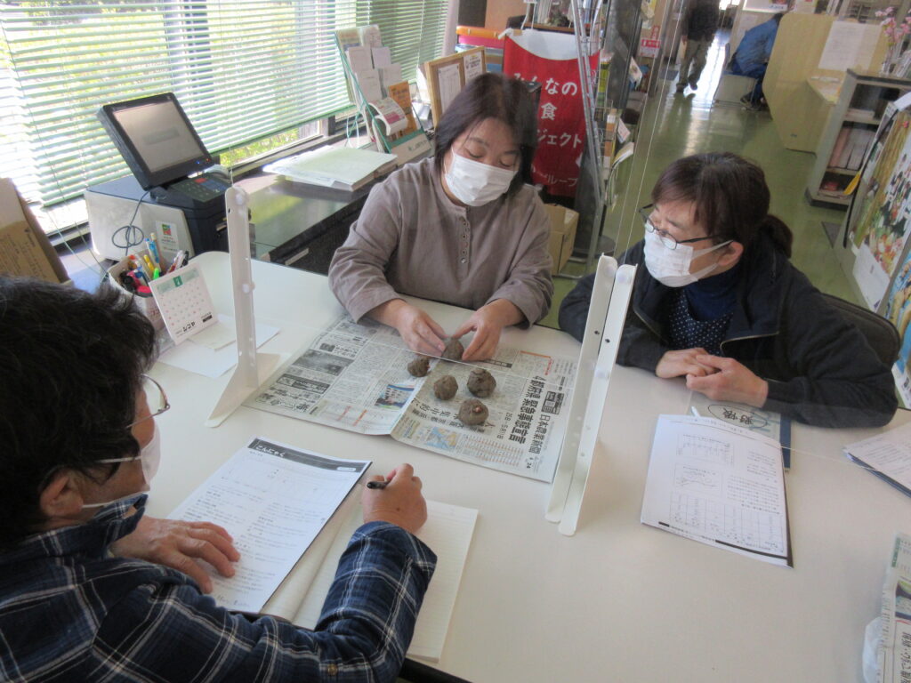 コンニャク芋の植え方について説明する髙橋支部長（左奥）