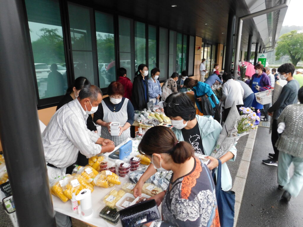 「朝市」にて、特産品を買い求める来場者（右）（８月１３日、宮城県南三陸町で）